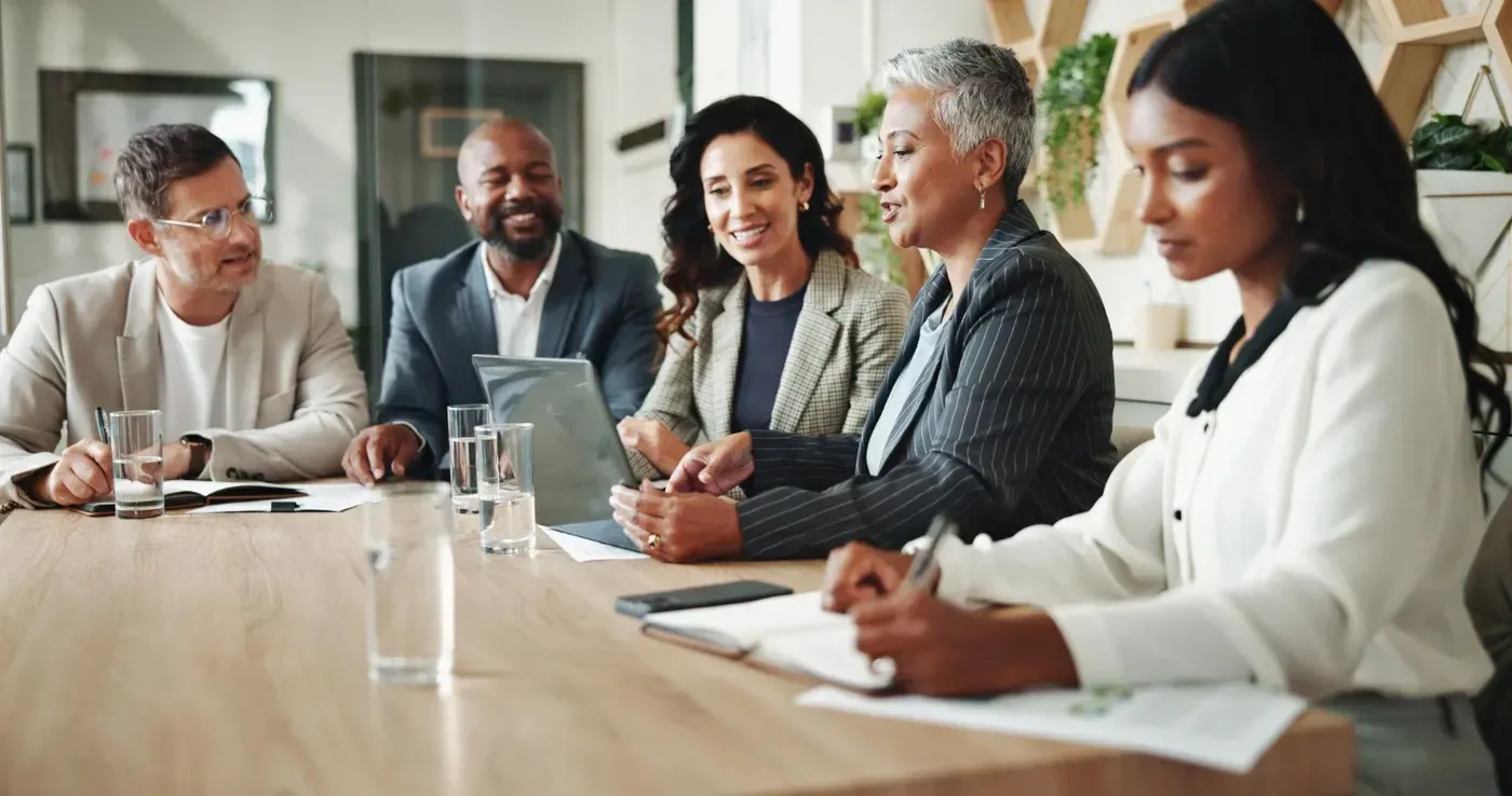 A diverse board of directors engaging in a strategic discussion at a conference table, representing corporate governance and effective leadership.