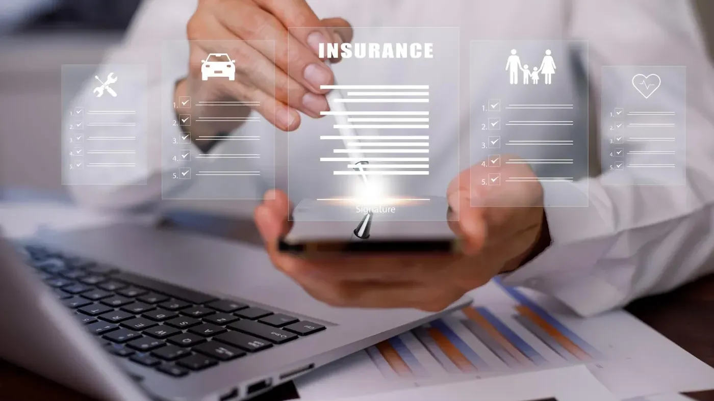 A person holding a phone with floating graphics showing different insurance coverages