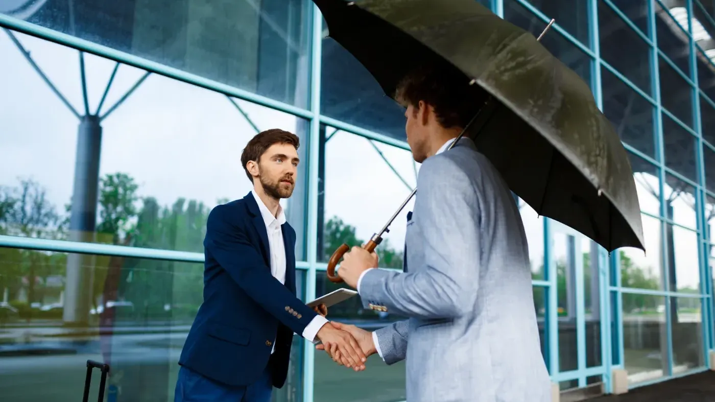 Two business professionals shaking hands outdoors