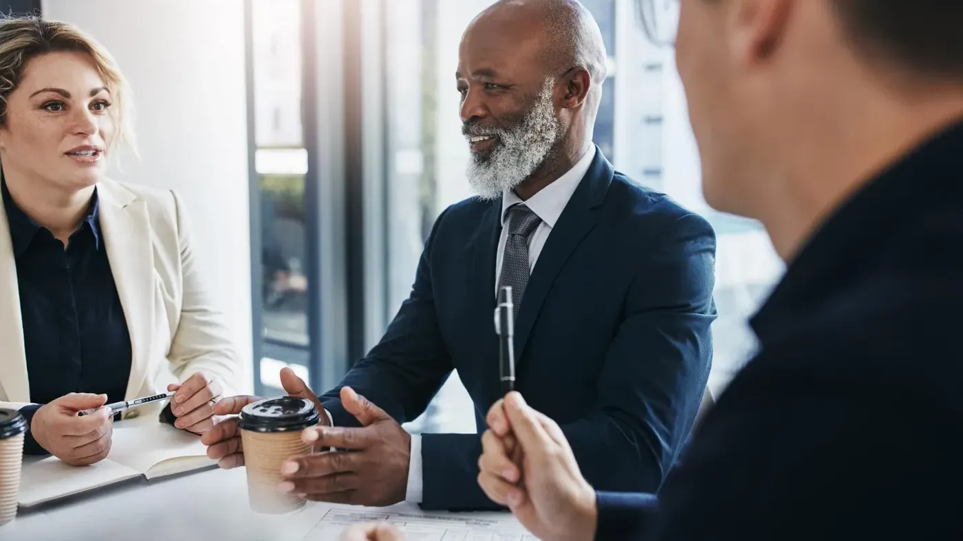 An experienced broker explaining the details of a liability business insurance quote to a female client during a professional consultation.