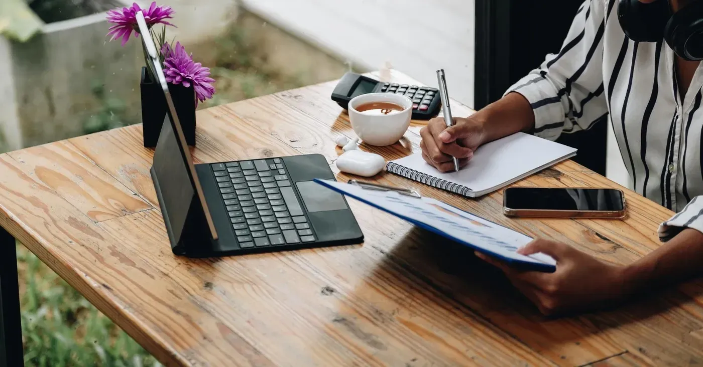 man writing notes on desk