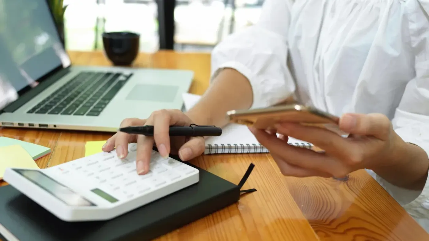 person typing on calculator